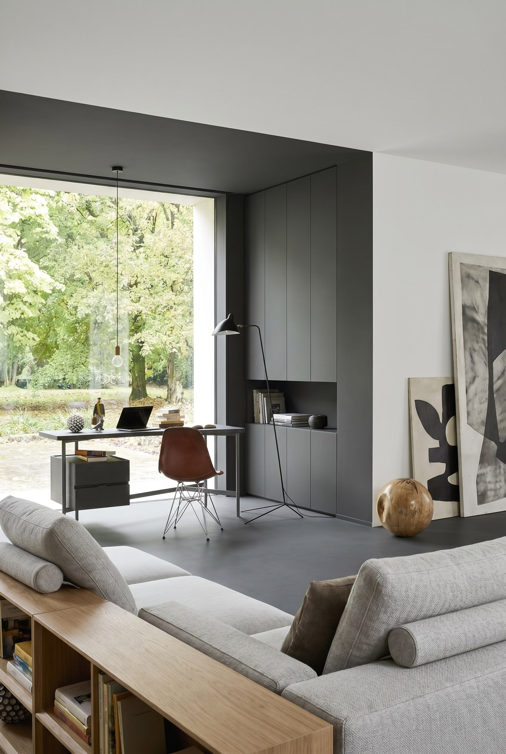 Monochromatic living room with light grey desk and brown leather chair