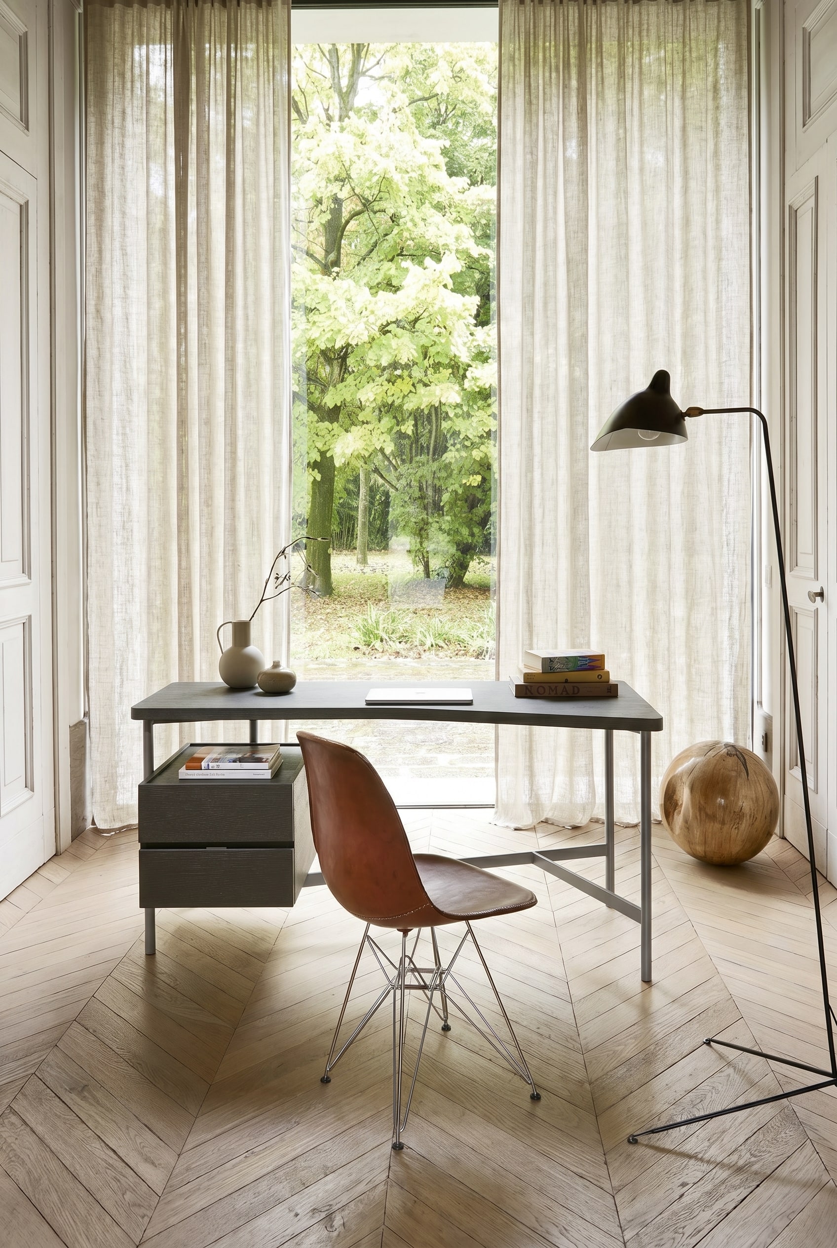 Ein sehr schlanker, minimalistischer Schreibtisch mit Metallgestell in einem hellen G&auml;stezimmer.