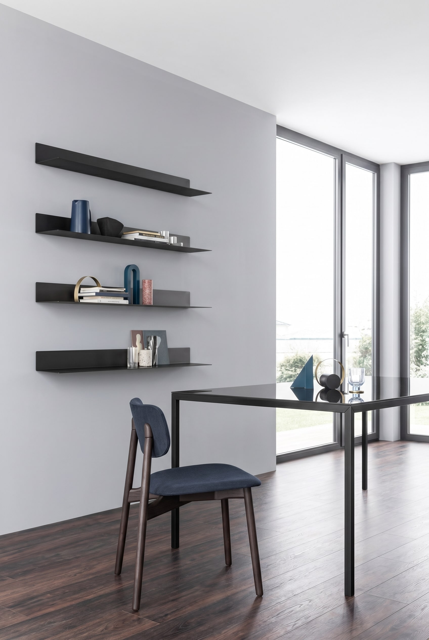 Minimalistischer Essbereich mit filigranen, ultraflachen Novamobili Wandregalen Ellie aus Metall, die asymmetrisch an einer hellgrauen Wand platziert sind
