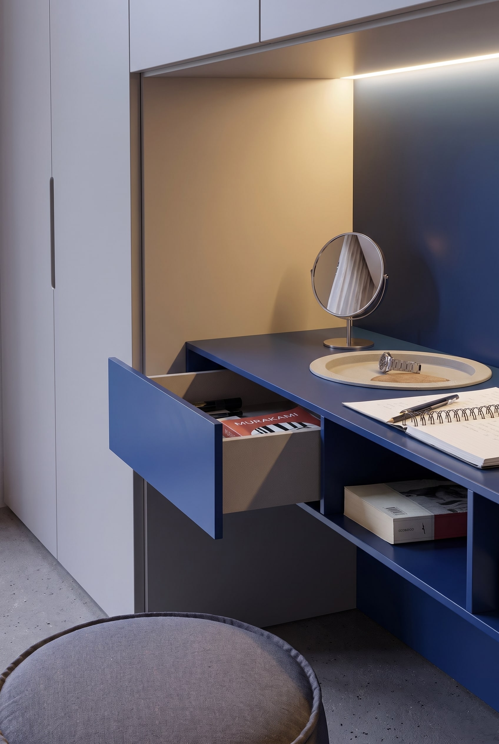 Opened blue drawer of the dressing table with books, next to it an open shelf under the tabletop.