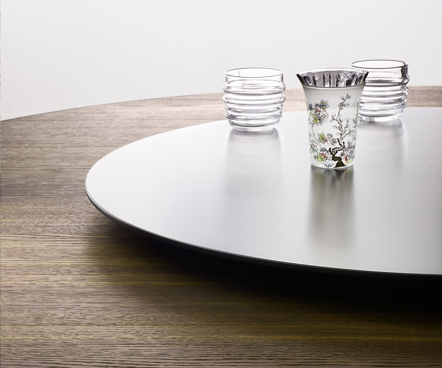 Detail of the swivelling top of the Livitalia Convivio dining table with drinking glasses on an oak table top Detail of the swivelling top of the Livitalia Convivio dining table with drinking glasses on an oak table top