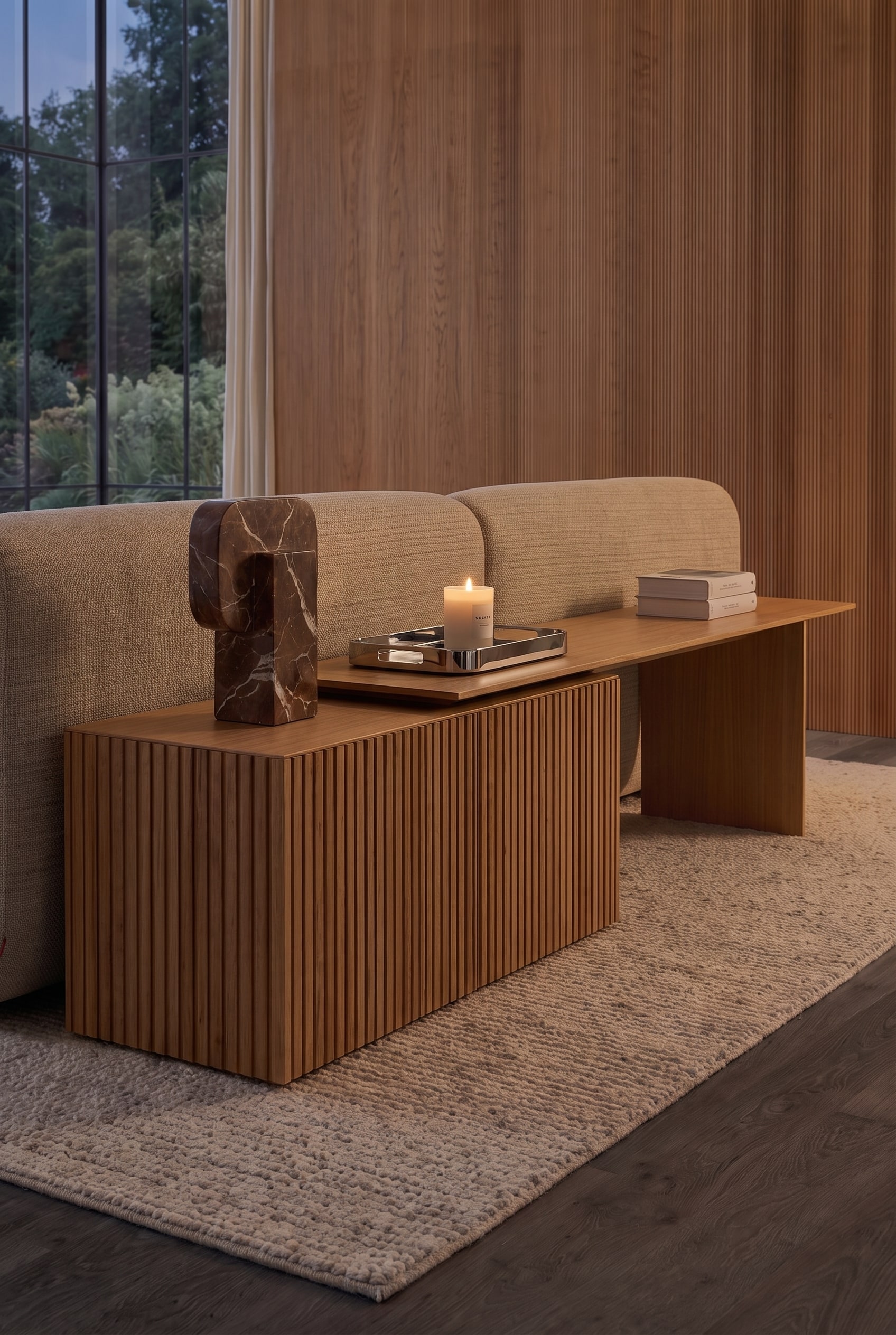 Detailed shot of the sideboard behind the sofa. Visible are the fluted profile, a tray with a burning candle, and a marble object.