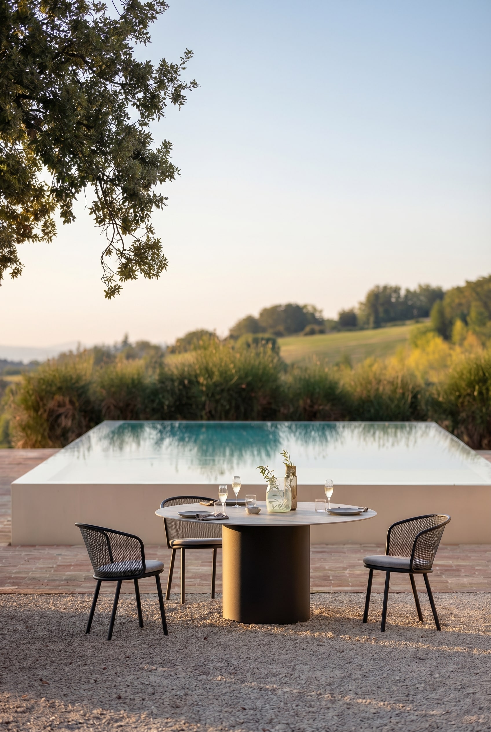Eleganter Gartentisch mit runder Keramikplatte und dunkler S&auml;ule