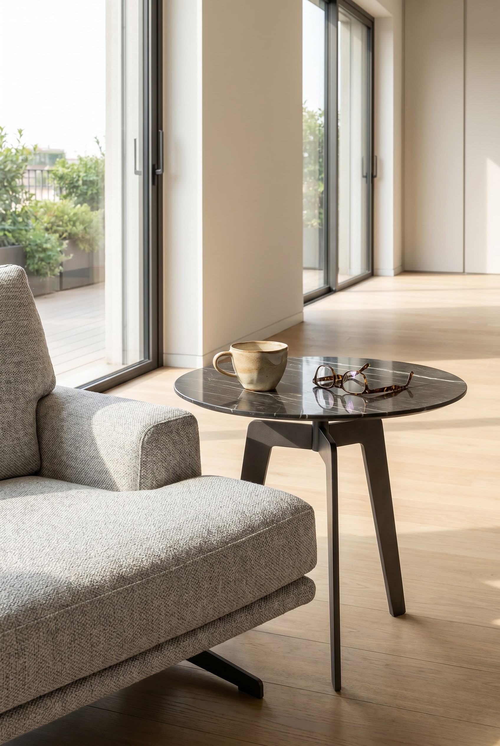 Minimalist Lotus side table in marble look next to a lounge chair with a white coffee cup