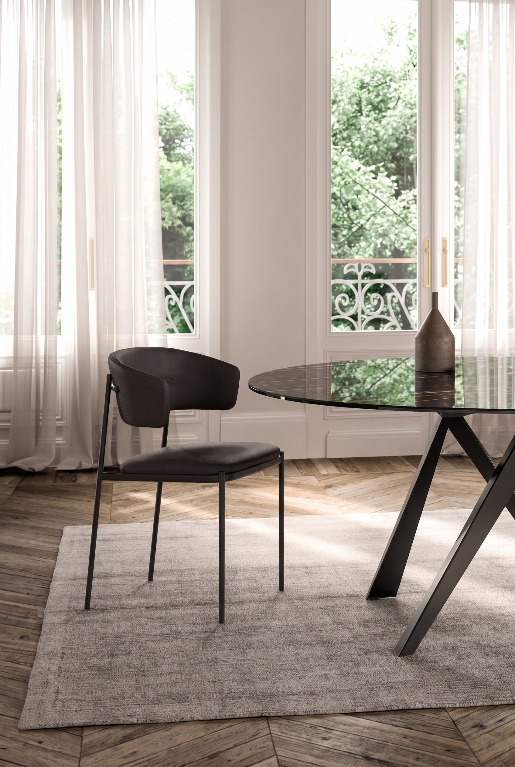 Bright dining room with a dark glass dining table and a dark, upholstered dining chair with a delicate metal frame.