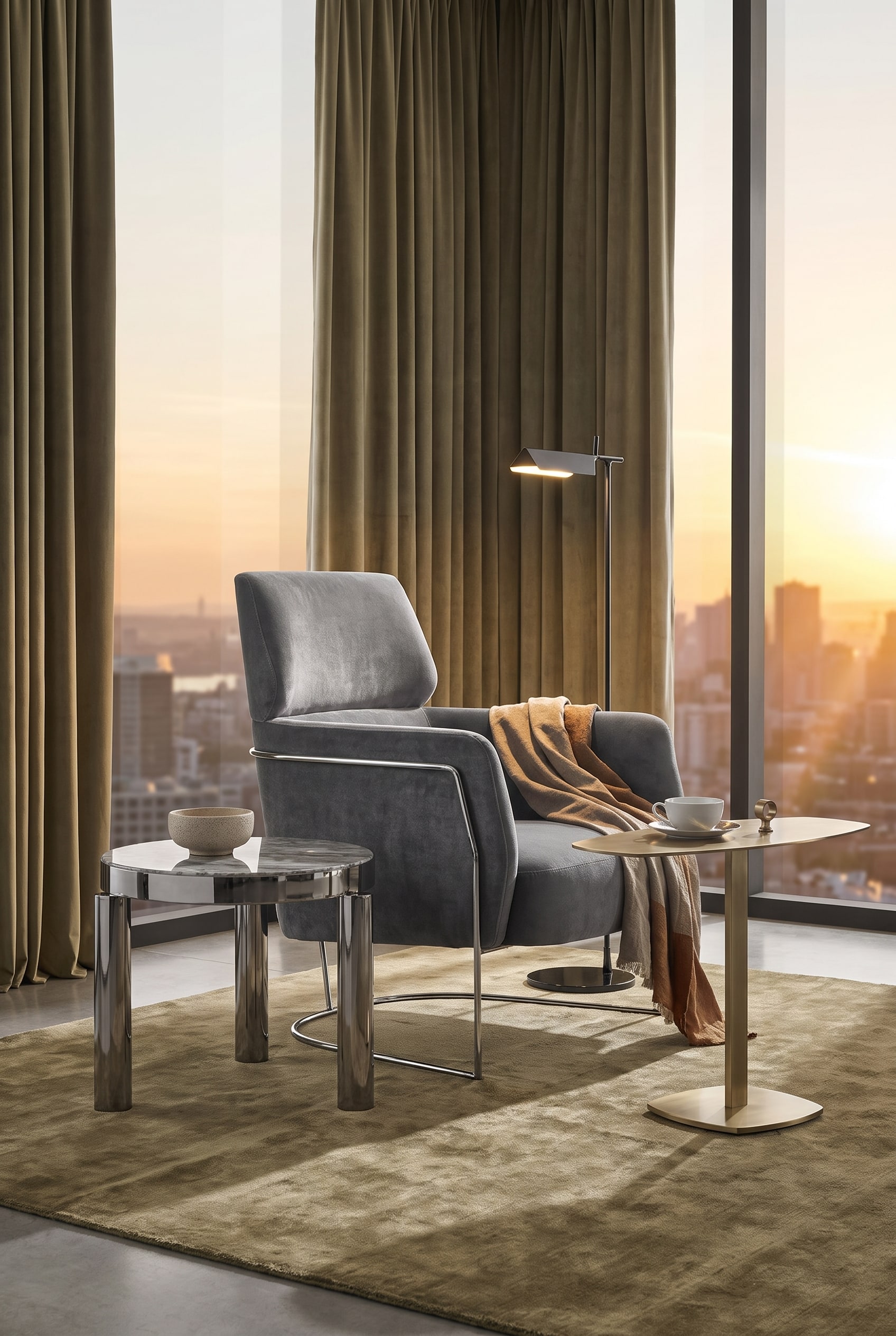 Lounge area with a khaki-coloured velvet armchair on a delicate chrome frame and a minimalist floor lamp
