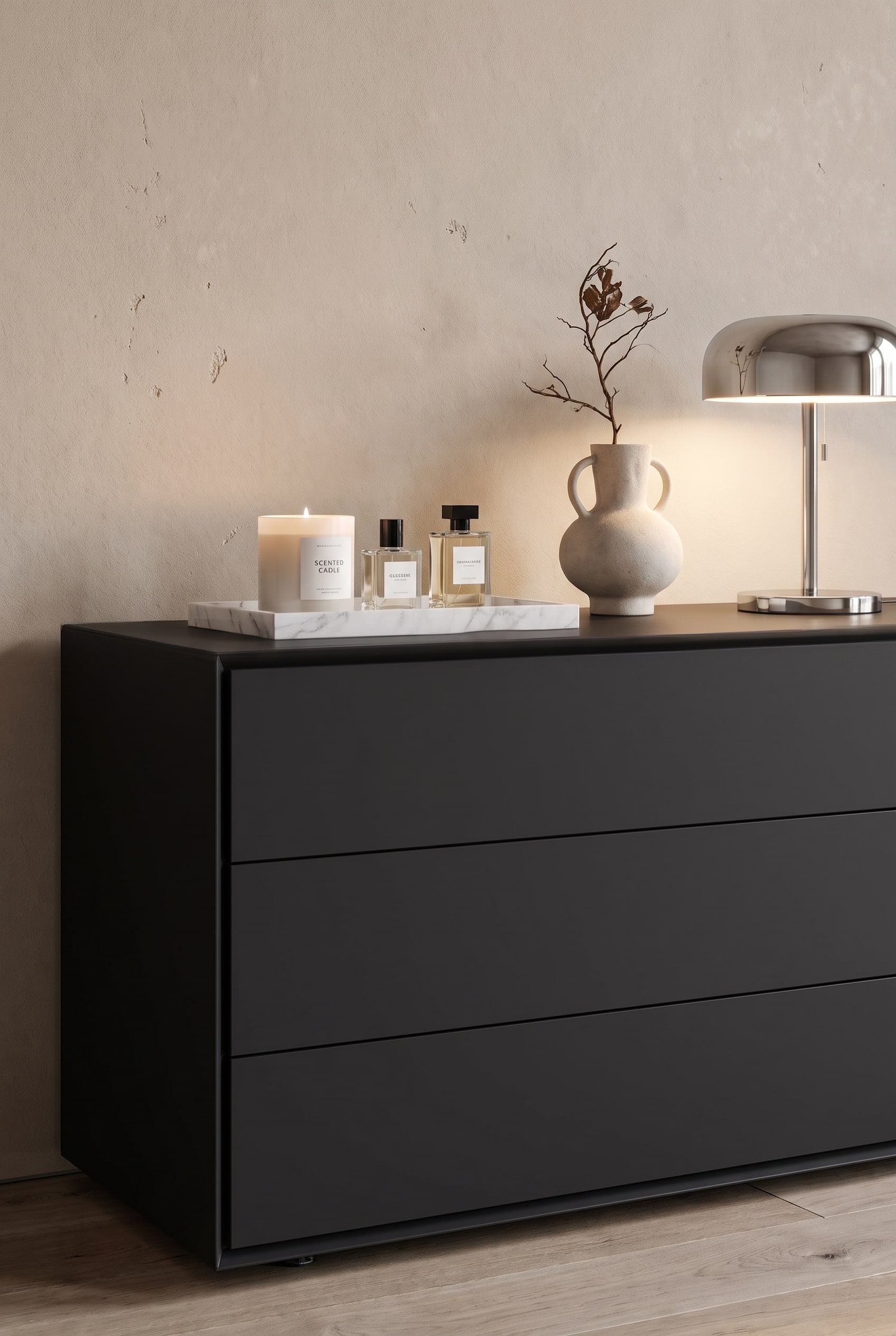 Matte Design-Kommode im Wohn-Schlafbereich, darauf gestapelte Bildb&auml;nde, eine skulpturale Vase und eine kleine Tischlampe