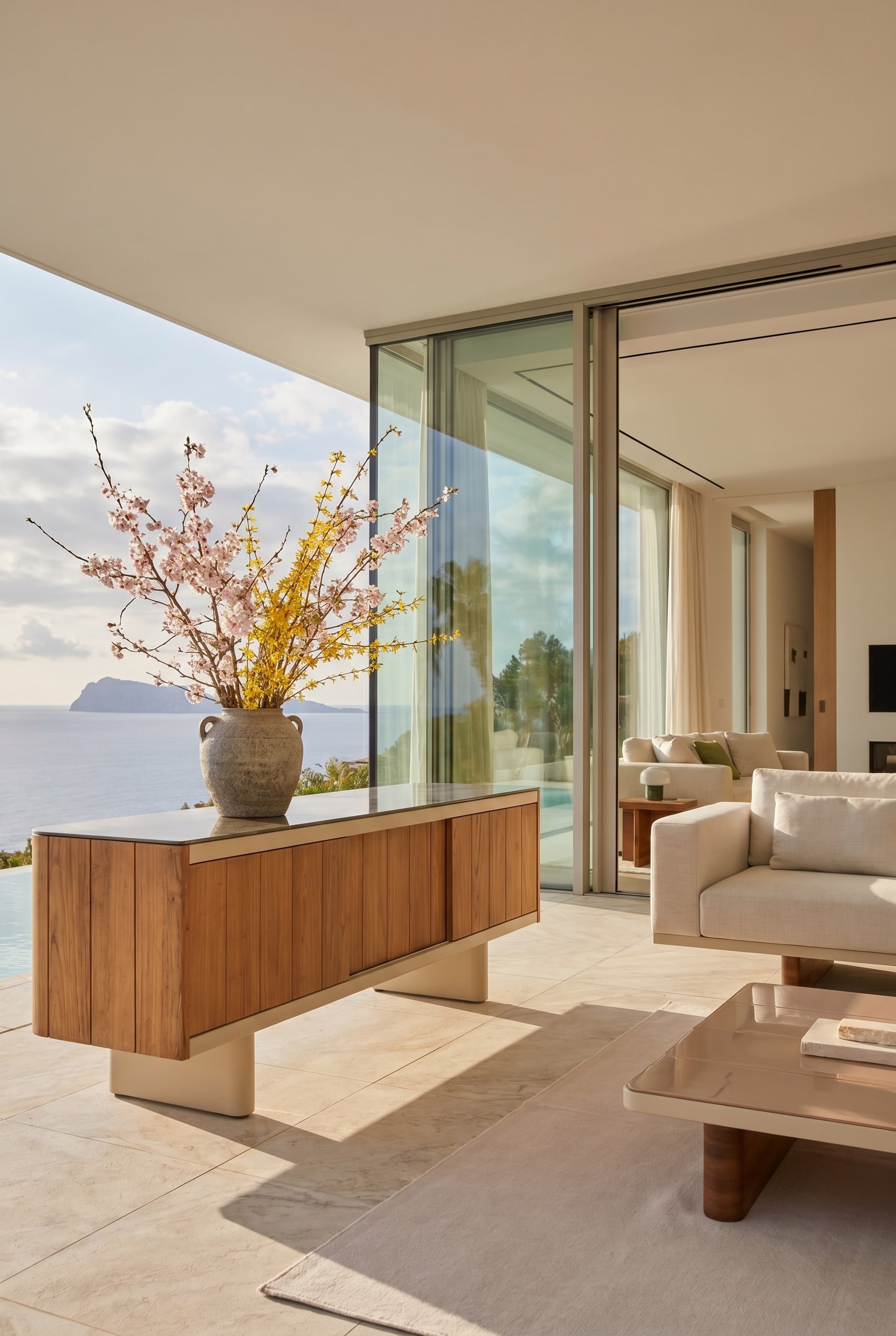 Elegantes Outdoor-Sideboard auf einer Loggia, dekoriert mit einer massiven Steingutvase und Frühlingszweigen Elegantes Outdoor-Sideboard auf einer Loggia, dekoriert mit einer massiven Steingutvase und Frühlingszweigen