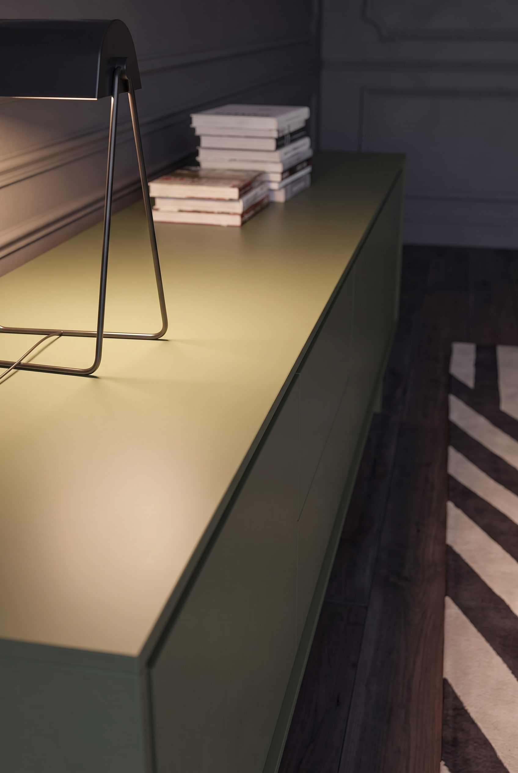 Macro shot of the smooth, matte lacquered top panel of an olive green sideboard.