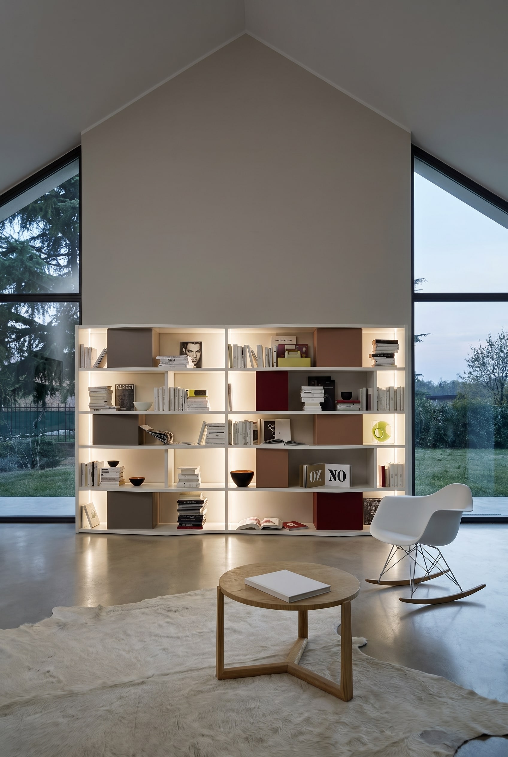 Tall, white bookshelf on a straight gable wall in the attic, stocked with books and colorful storage boxes
