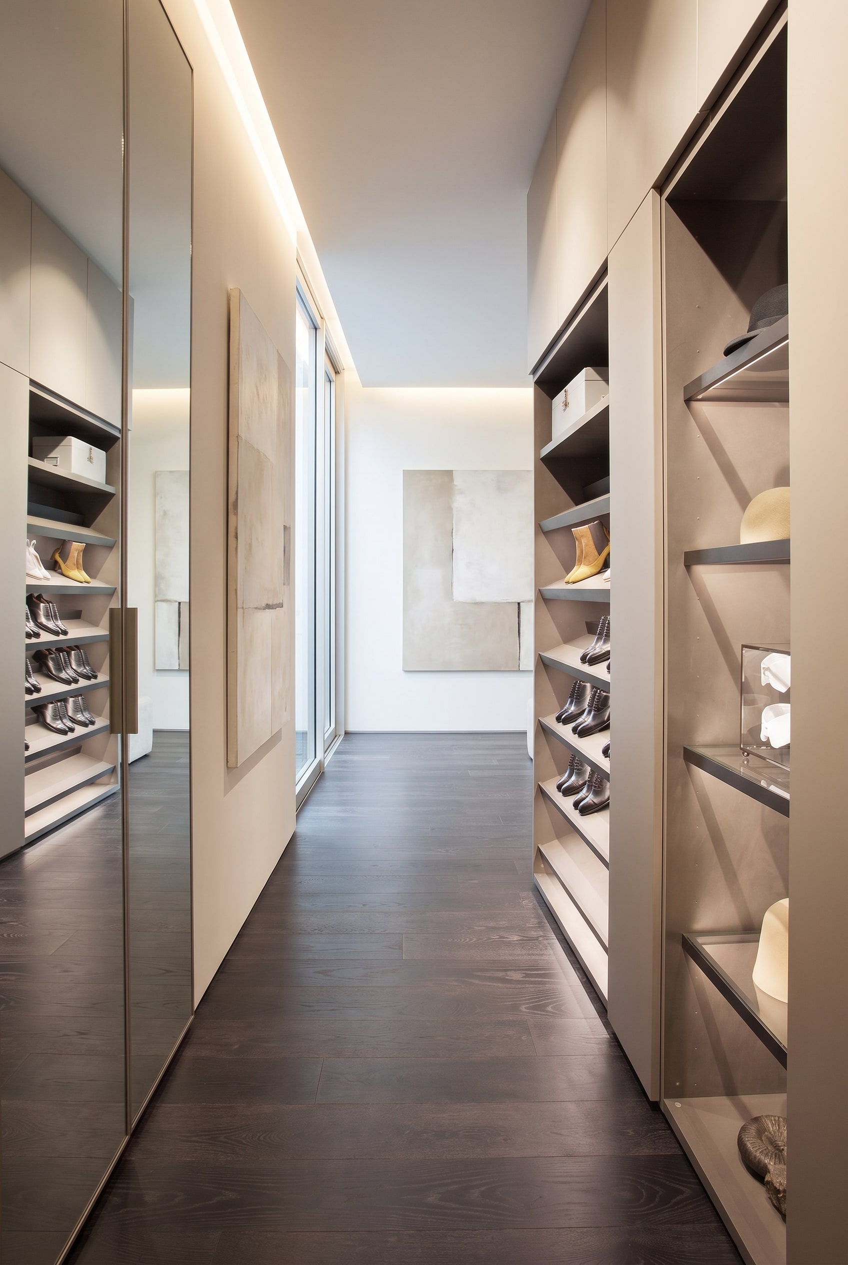 A slightly open modern shoe cabinet in the hallway, showing slanted shelves with integrated LED lighting inside.