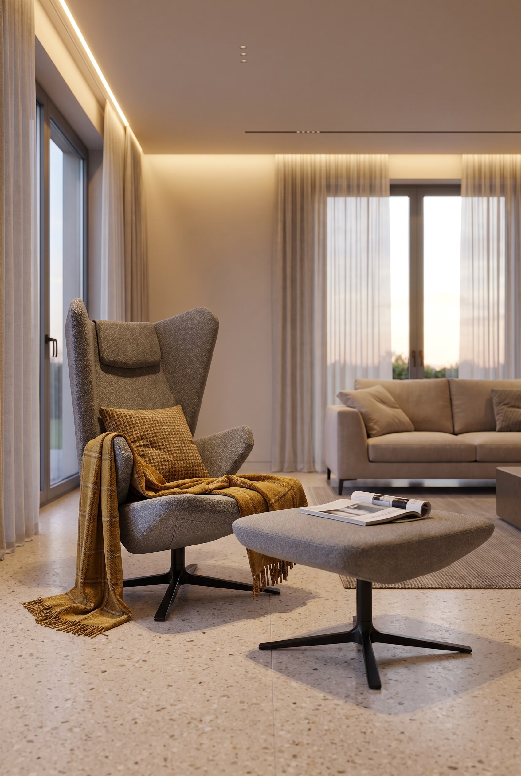 Round grey pouf next to a beige sofa, over which a mustard yellow plaid is casually draped