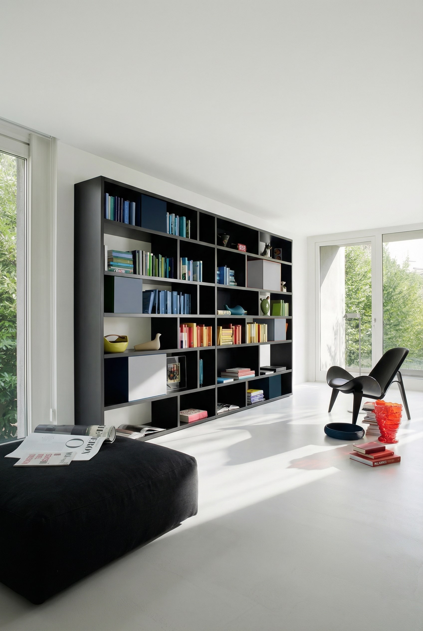 Schwarzes Livitalia B&uuml;cherregal C85 als starker Farbkontrast vor einer hellen Wohnzimmerwand.