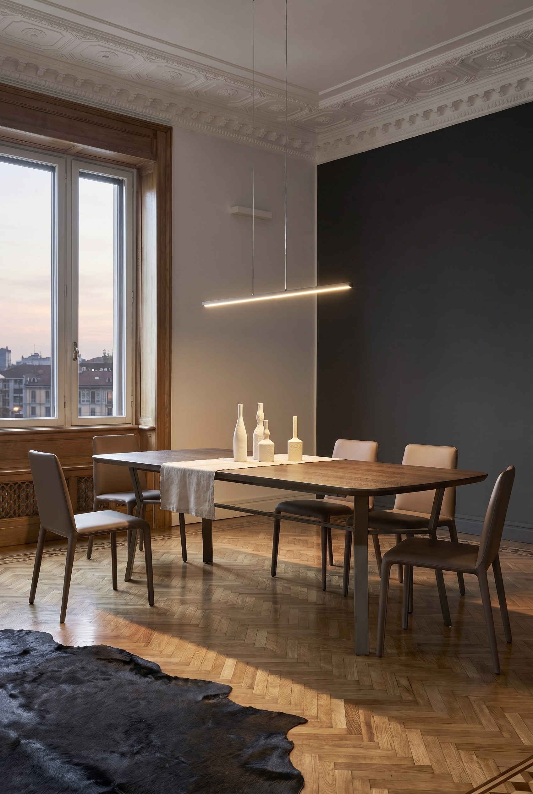 Industrial-chic dining room with a linear dining table, striking dark metal frame, and minimalist chairs