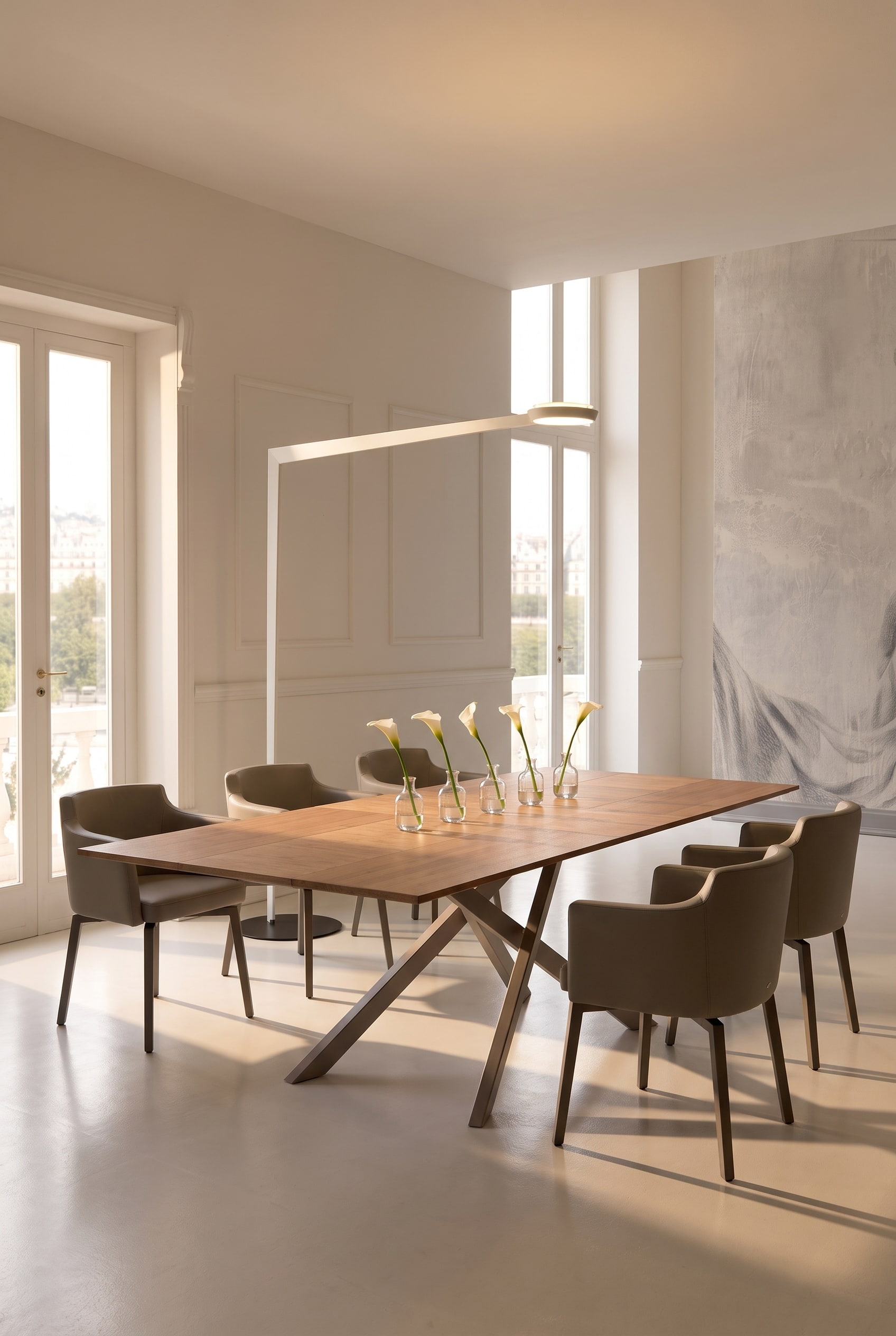 Spacious dining room with long wooden dining table, lined up small glass vases and taupe leather armchairs