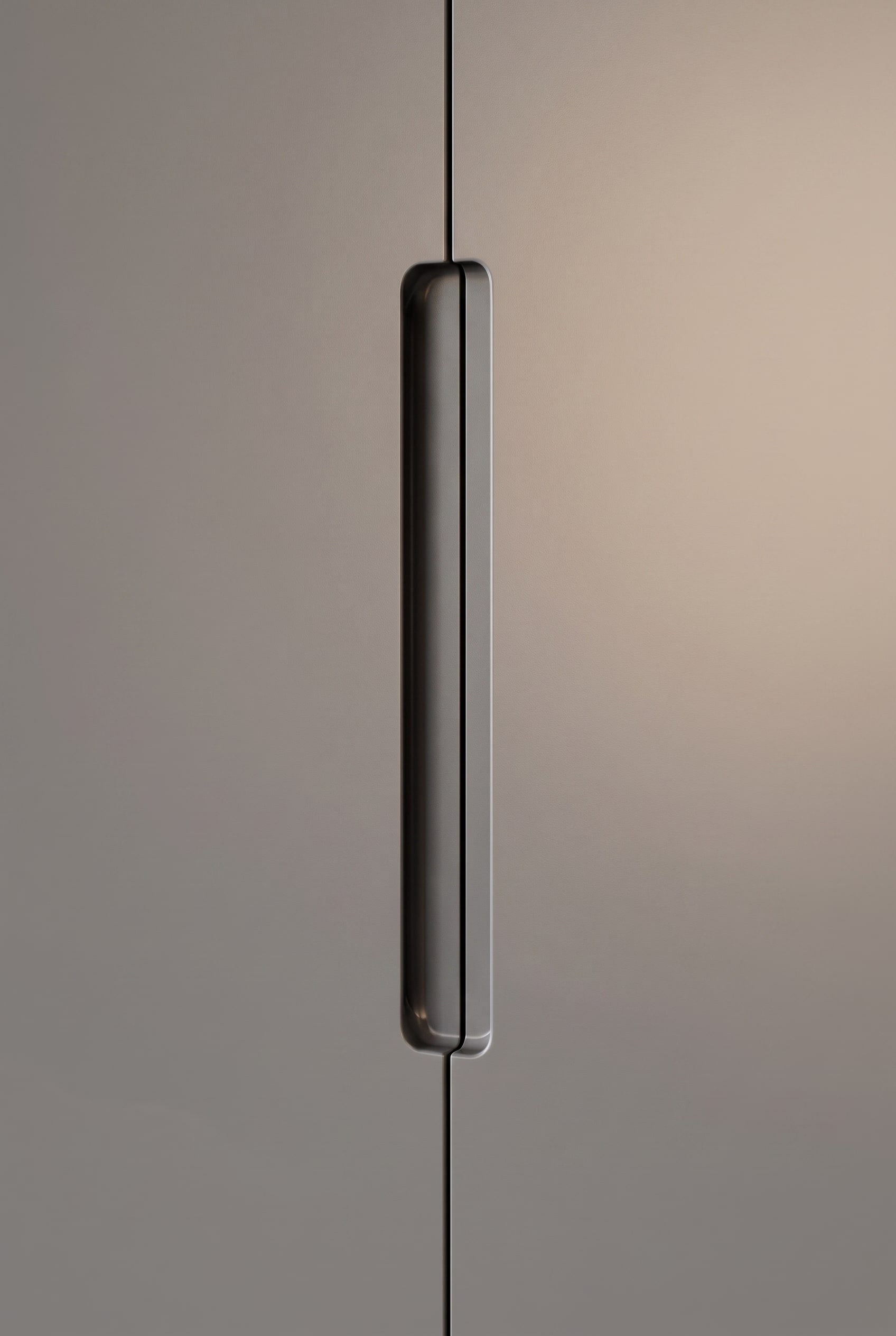 Close-up of a flush-milled, dark lacquered handle on a gray wardrobe door.