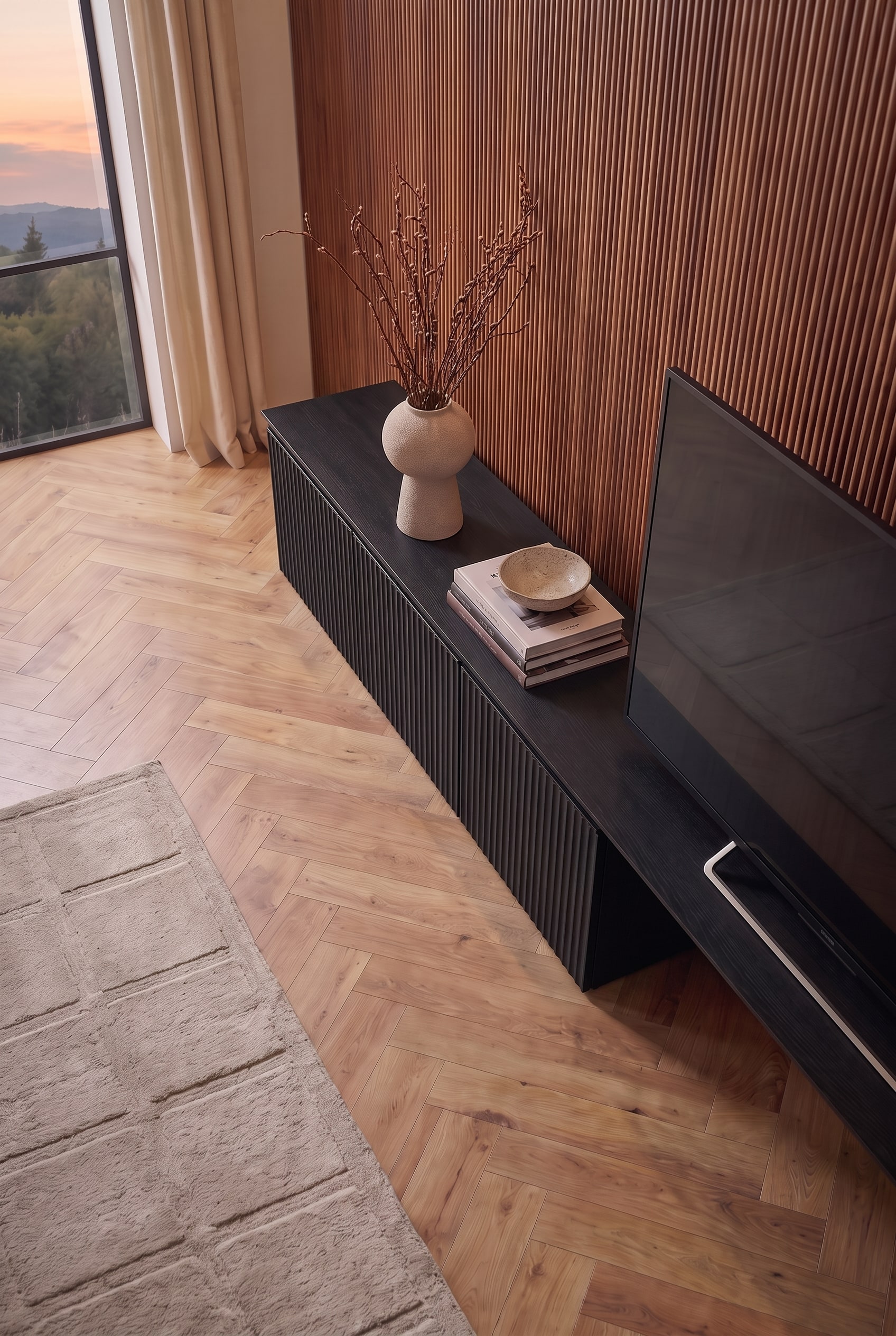 Oblique view of the black TV lowboard. Books, a bowl, and a vase enliven the area next to the screen.