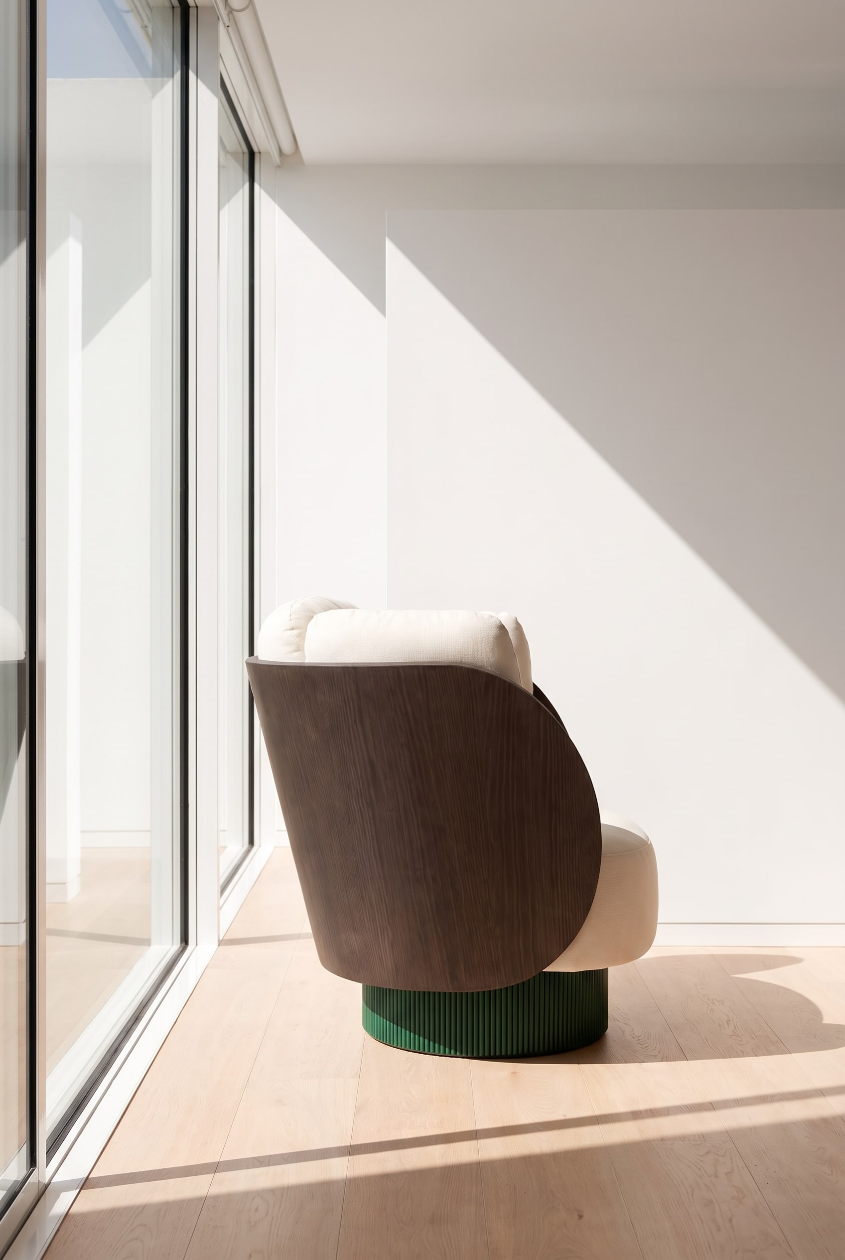 Side view of the armchair, showing the curved wooden backrest and voluminous upholstery.