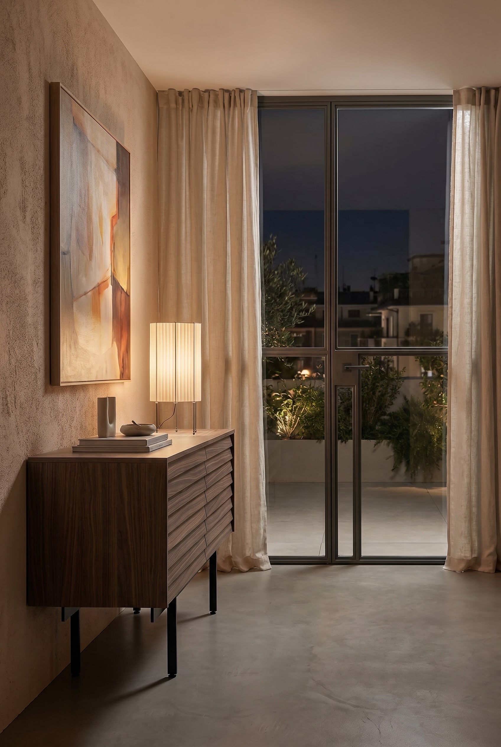 Gem&uuml;tliches Schlafzimmer mit niedrigem Holz-Sideboard und Tischleuchte mit plissiertem Stoffschirm in Beige bei warmem Licht