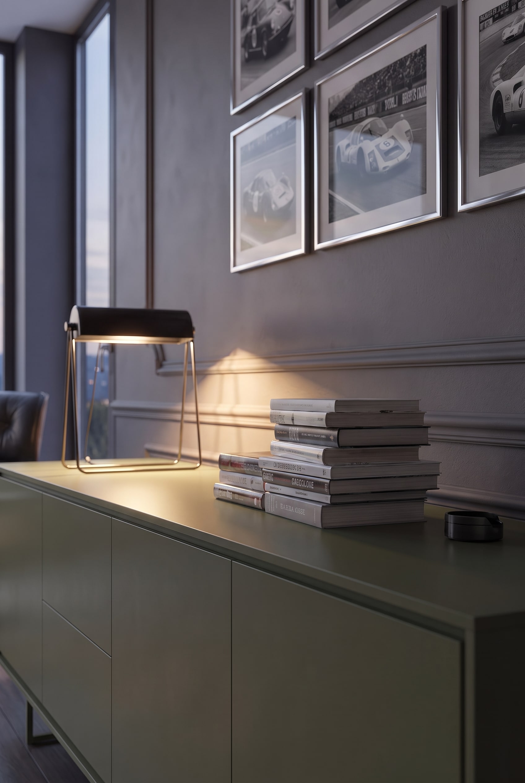 Close-up of horizontally stacked books and a modern table lamp on a matte sideboard.