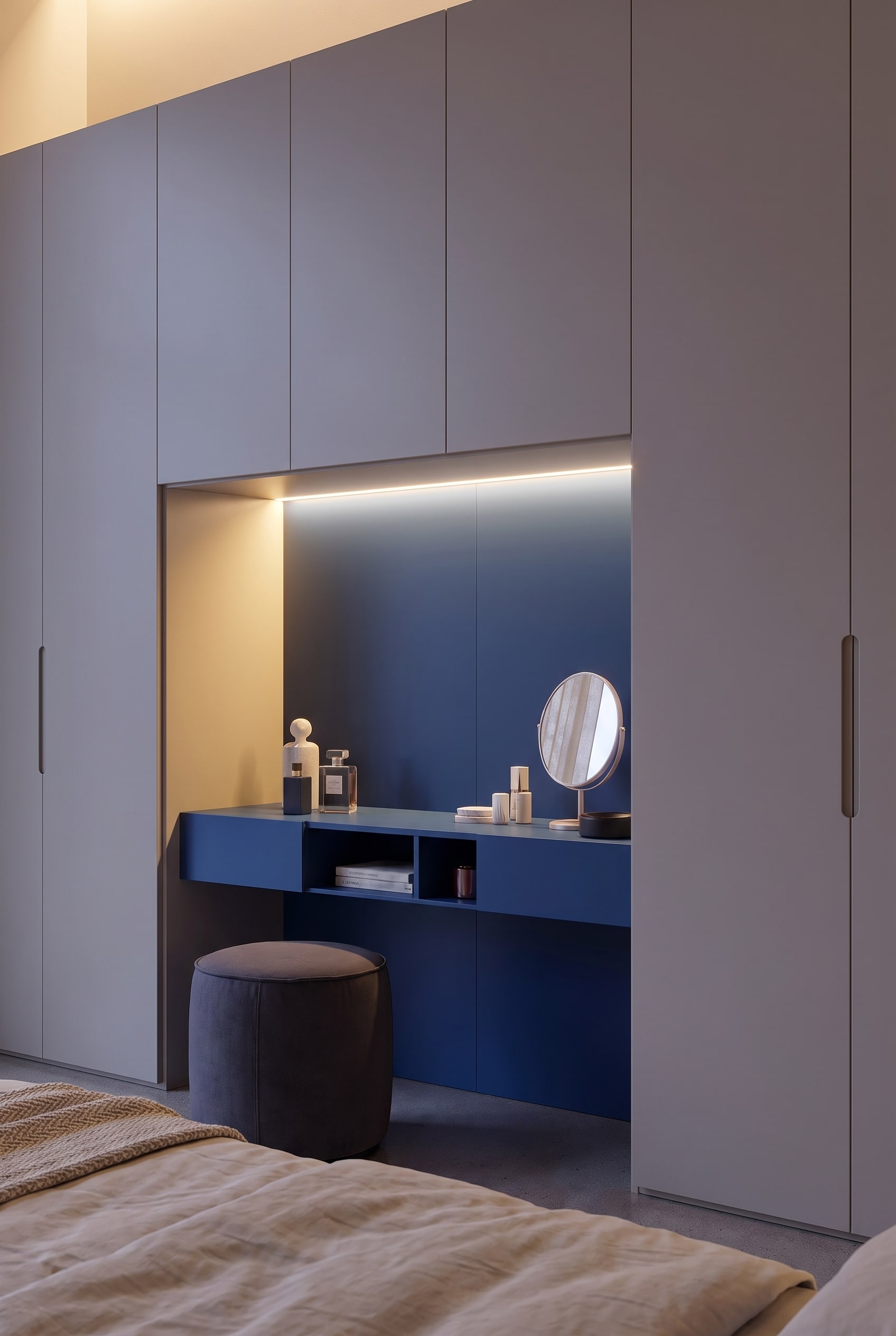 Detailed shot of the blue wardrobe niche with illuminated dressing table, round mirror, and perfume bottles.