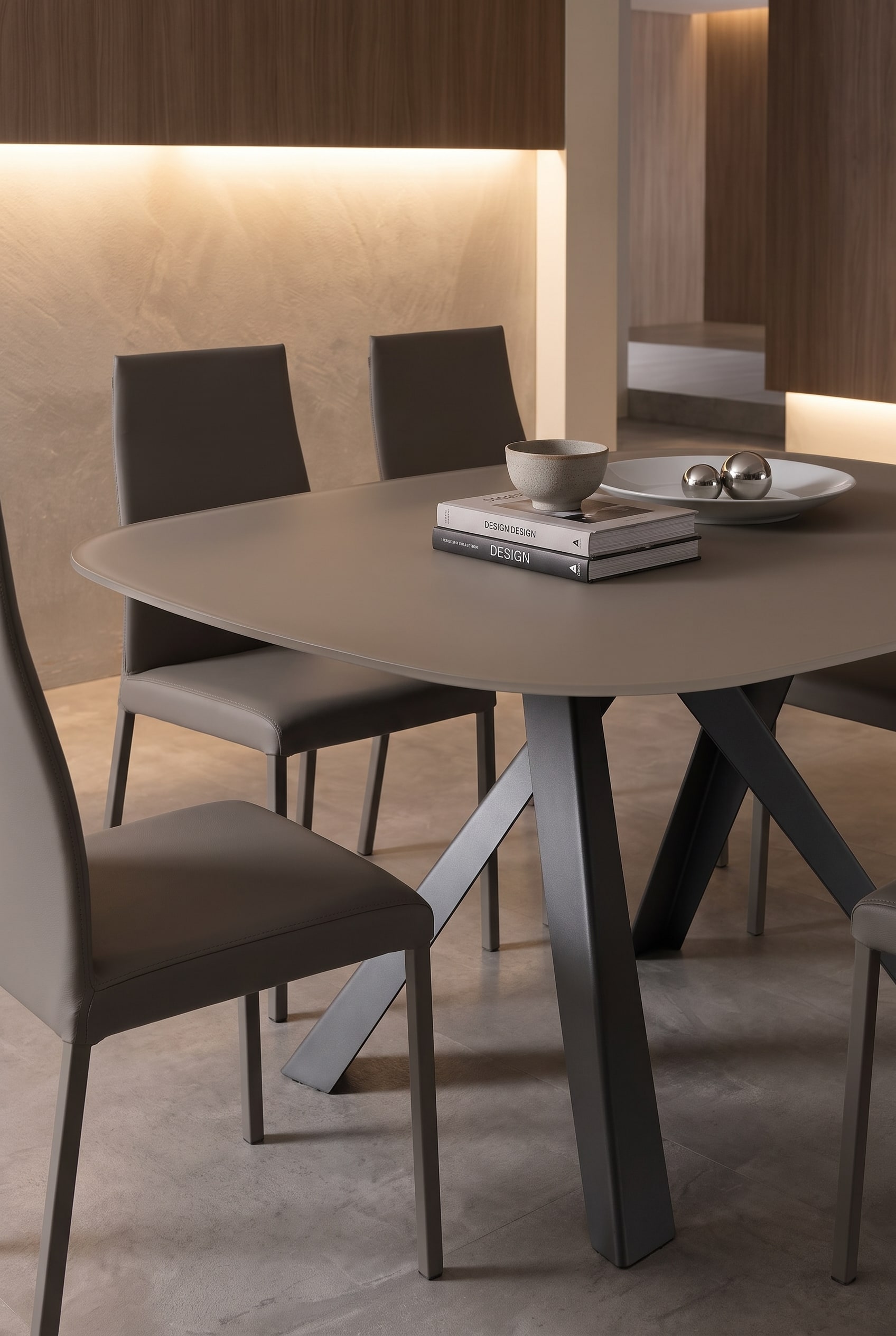 Filigraner Ozzio Esstisch Bombo mit d&uuml;nner kratzfester Platte und eleganten Esszimmerst&uuml;hlen in warmem Licht