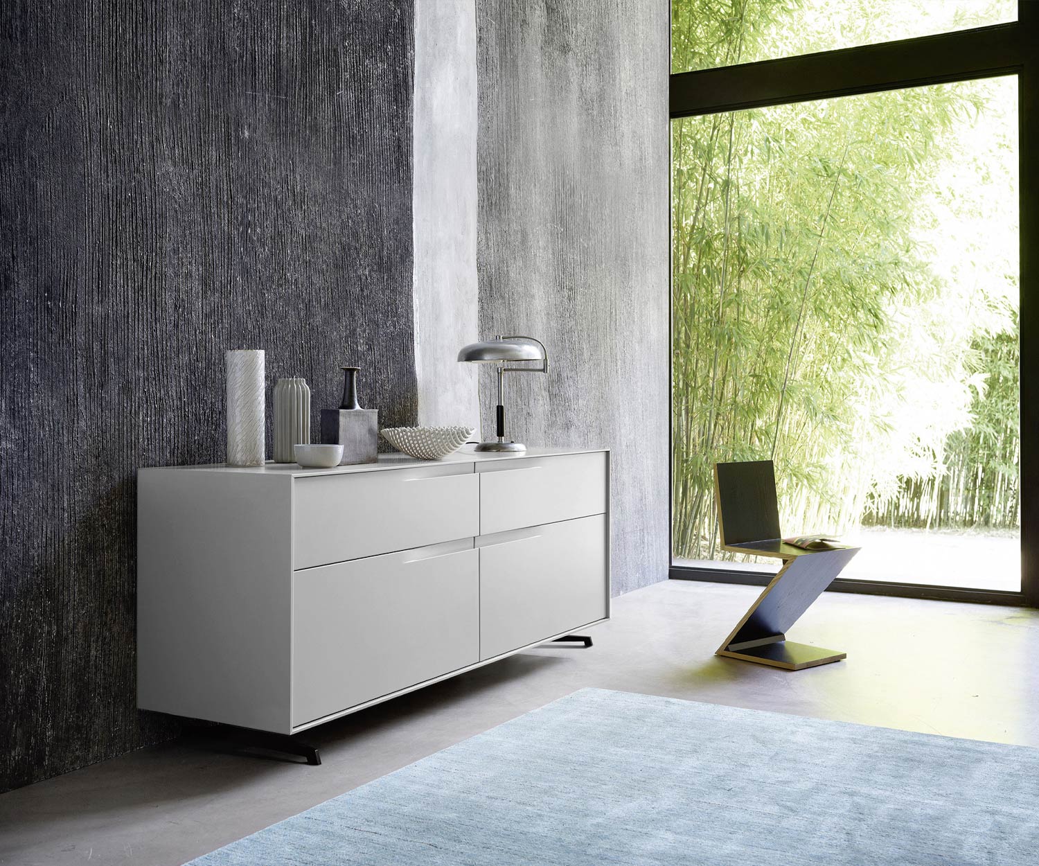 Designer Kommode Vela matt lackiert Grau im Schlafzimmer vor Fensterfront