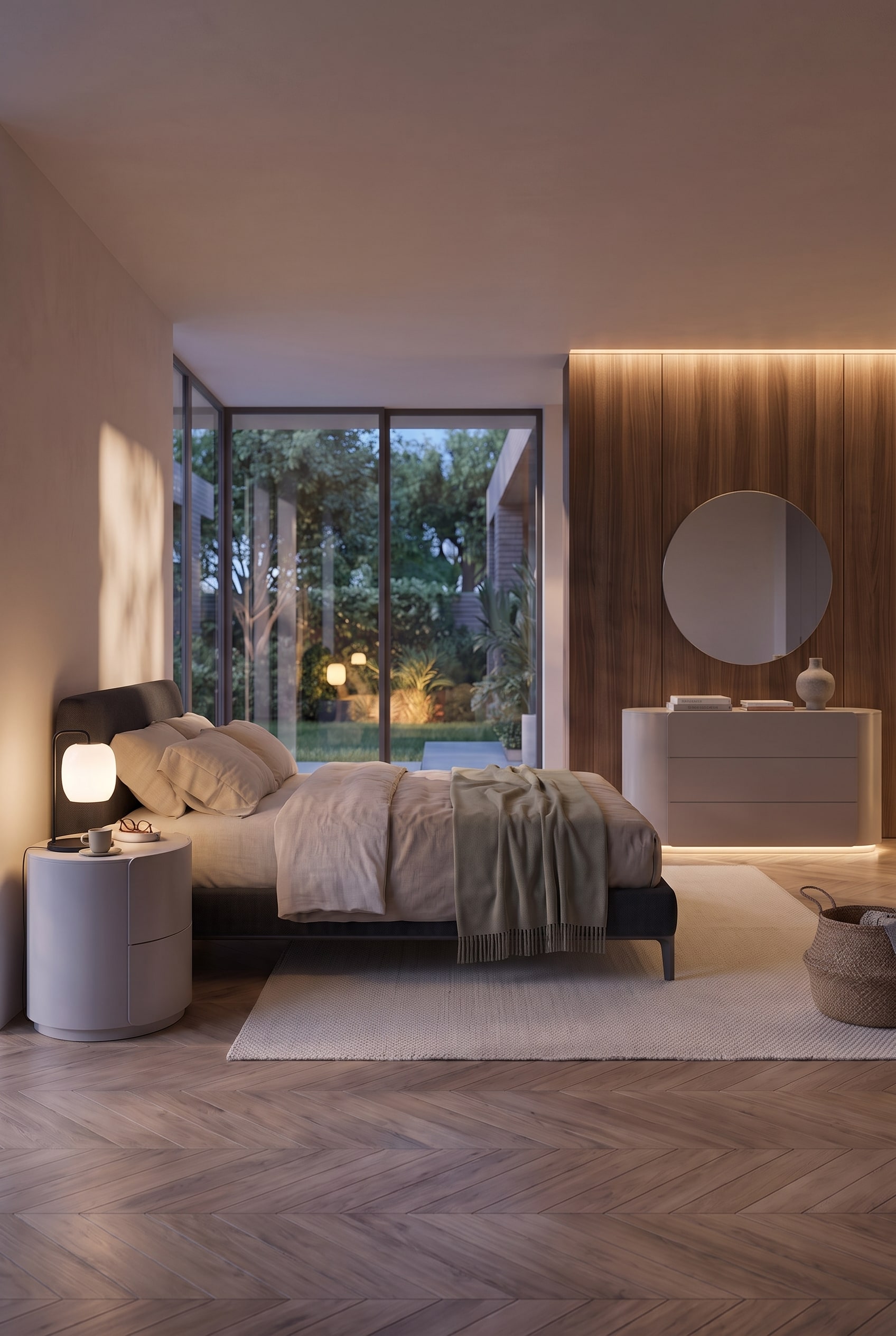 Modern bedroom in a total view, showing a round bedside table, bed, and rounded chest of drawers in front of wooden panels.