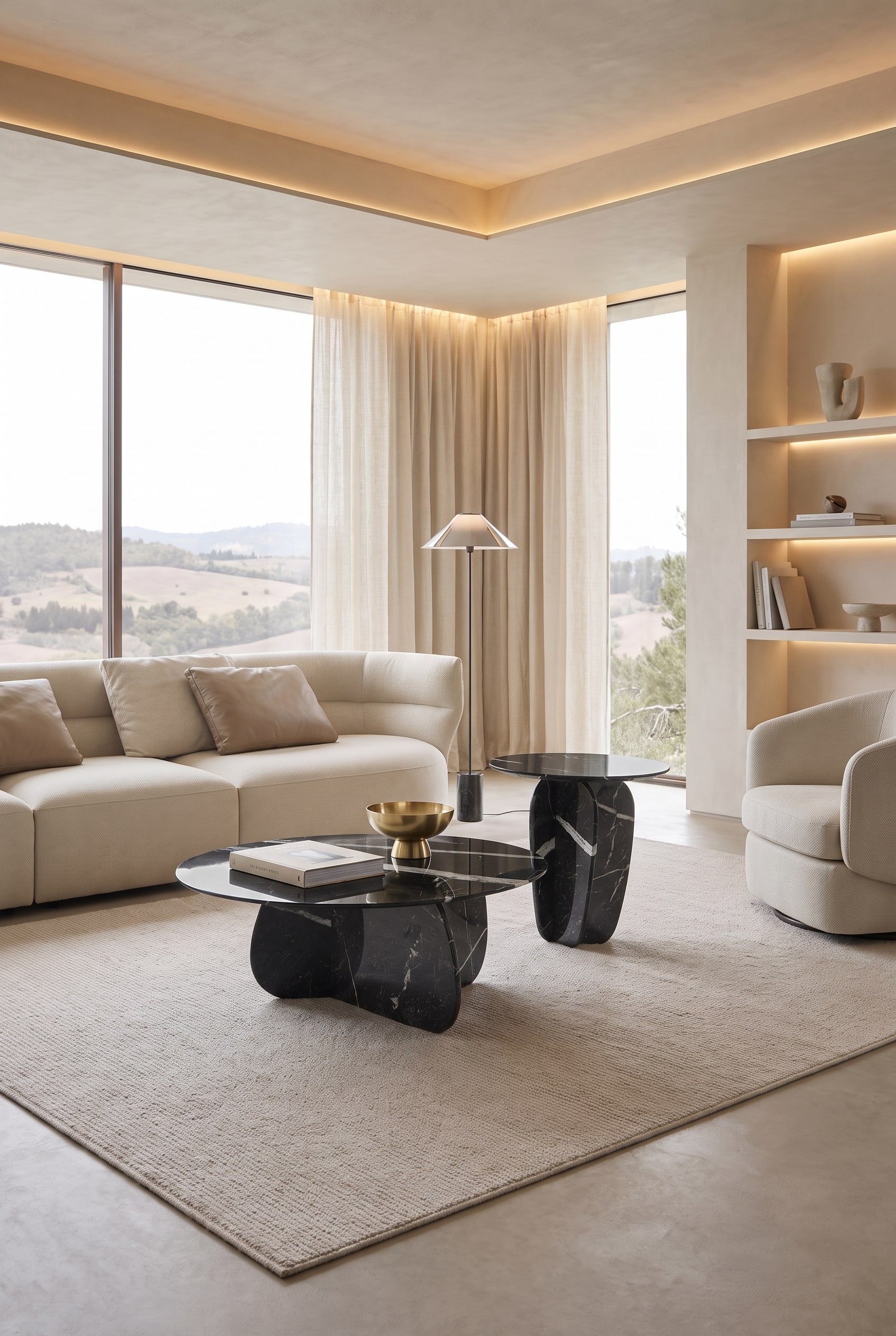 Living room with two organically shaped coffee tables made of dark marble on a light carpet, with floor-to-ceiling windows and indirect lighting in the background