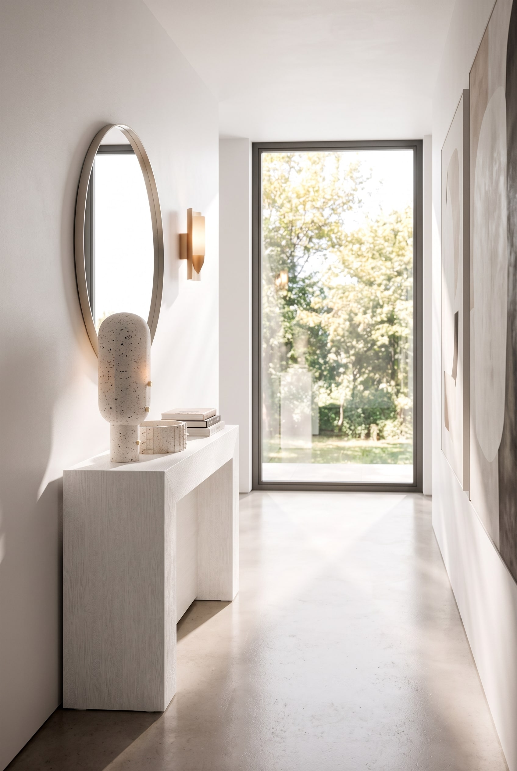 Narrow hallway with an extremely flat white console, above it a round wall mirror and a minimalist wall lamp