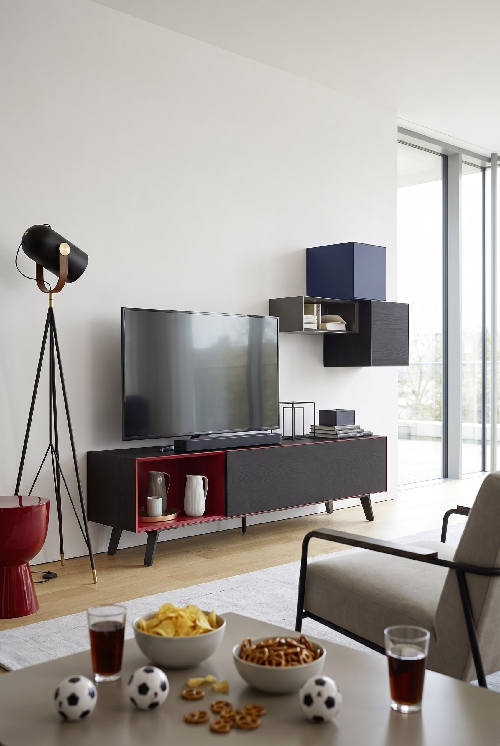 Minimalist living room with a matte white lowboard, a large television, and a compact soundbar in front of it