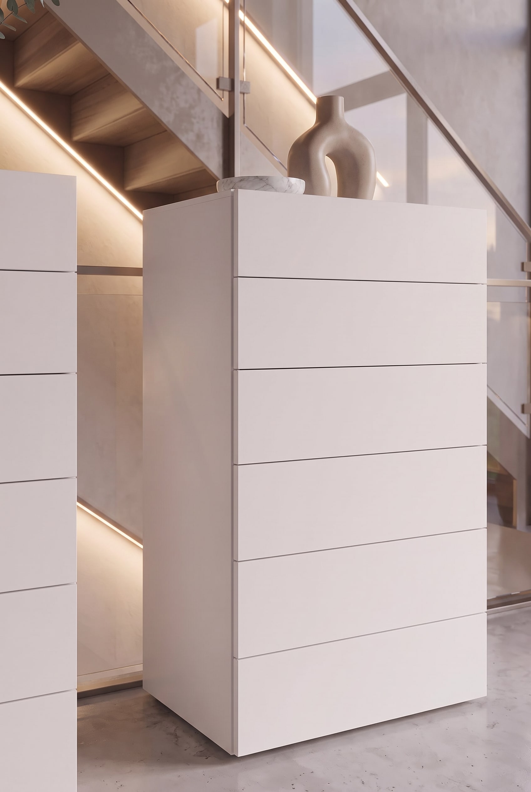 Detail shot of a white tall chest of drawers with handleless drawers and a fine shadow gap.
