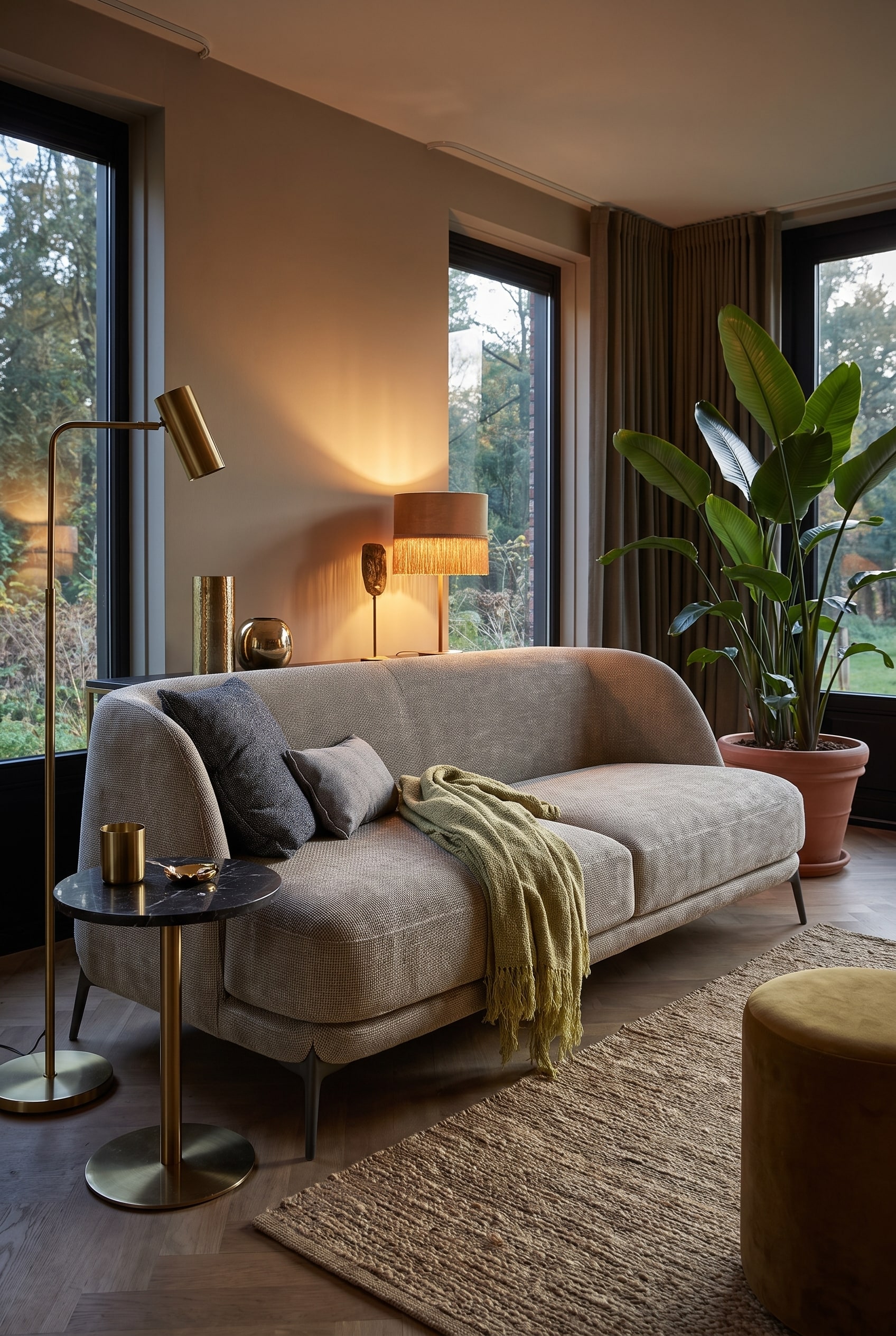 Wohnzimmer im Boho-Glamour-Stil mit einem organisch geformten Samtsofa in warmem Farbton, erg&auml;nzt durch Messing-Details und gro&szlig;e Pflanzen
