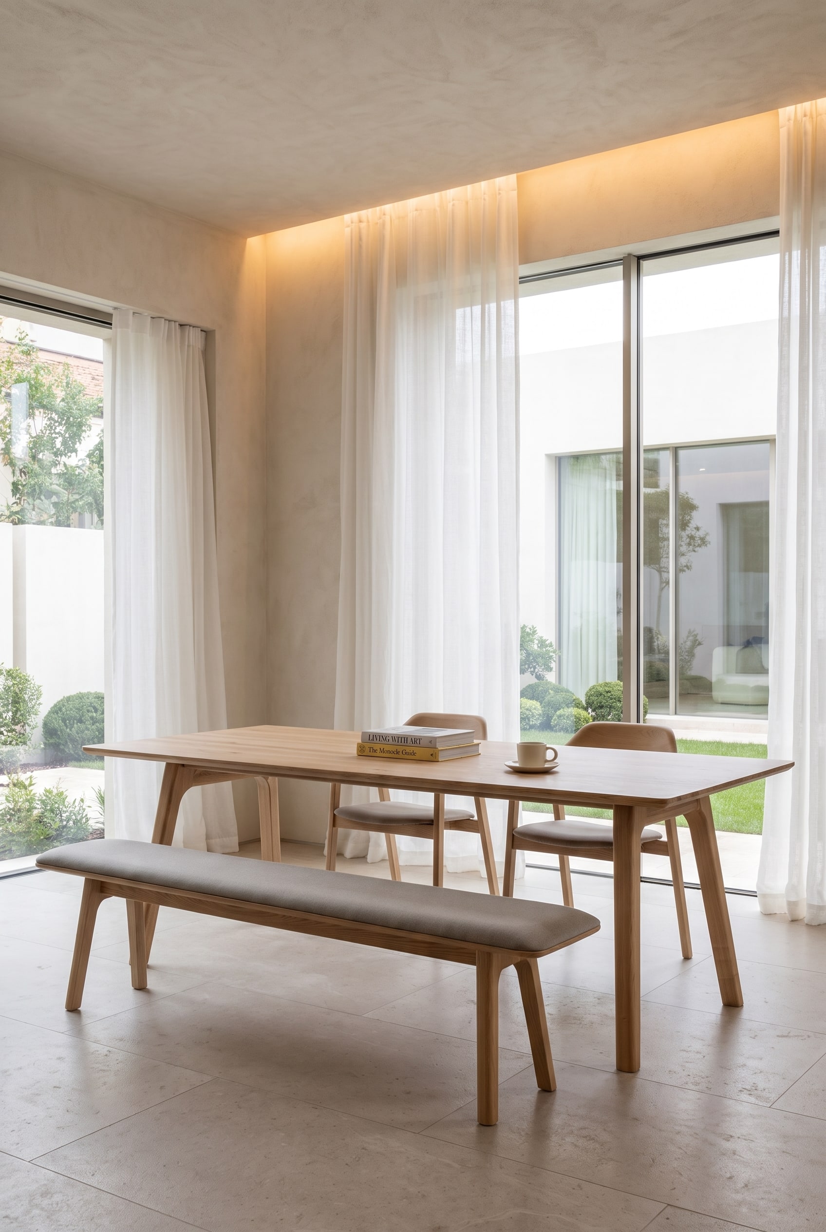 Spacious dining room with a wooden dining table, an upholstered wooden dining bench on one side, and individual dining chairs on the other side.